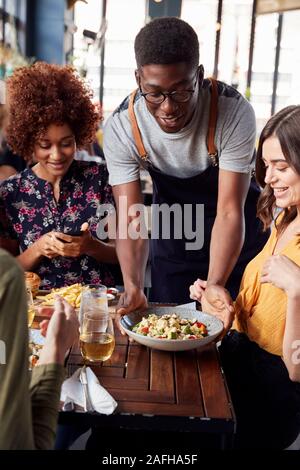 Kellner, die Gruppe der weiblichen Freunde treffen für Getränke und Essen im Restaurant Stockfoto