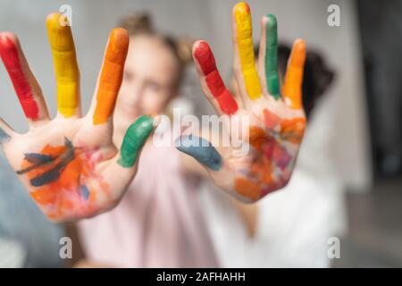 Kleines Mädchen mit bunten Palmen zu Kamera Stockfoto