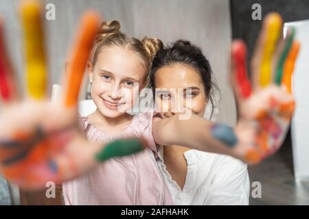 Nettes hübsches Mädchen mit Palmen zu Kamera farbig lackiert Stockfoto