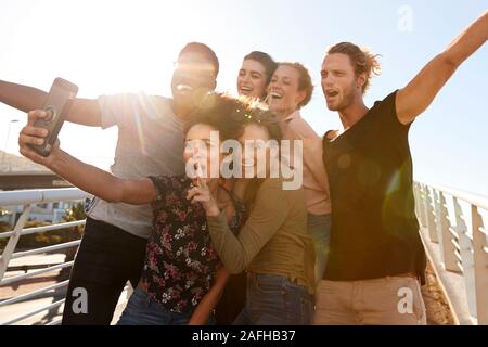 Lächelnden jungen Freunde Posieren für Selfie auf Outdoor Steg zusammen Stockfoto
