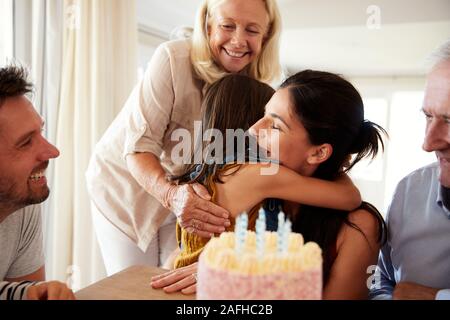 Mitte der erwachsenen Frau ihre Tochter nach dem Ausblasen der Kerzen auf der Geburtstagstorte, in der Nähe Stockfoto