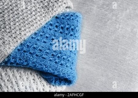 Stilvolle gestrickt, pastellfarbenen Pullover und eine trendige blaue Farbe in verschiedenen Strickmuster auf Samtigen Stoff Hintergrund angehäuft. Flach Stil Stockfoto
