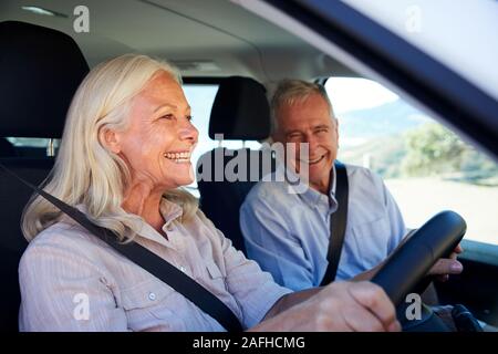 Senior weiß Frau fahren Auto, ihr Mann neben ihr im Beifahrersitz, Nahaufnahme, Seitenansicht Stockfoto