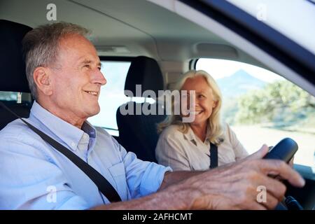 Senior weiße Mann fahren Auto, seine Frau, die neben ihm auf dem Beifahrersitz, Nahaufnahme, Seitenansicht Stockfoto