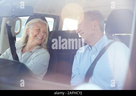 Happy senior weiß Paar in ihrem Auto an jeder anderen lächelnd fahren, durch die vordere Windschutzscheibe Stockfoto