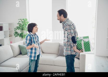 Profil Seitenansicht Portrait von zwei netten attraktiven Heiter Heiter froh Kerle Papa Papa verstecken Schleifenband Box vor - jugendlich Sohn raten warten in Licht Stockfoto