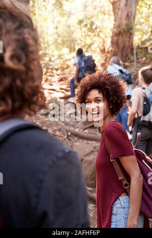 Gruppe der tausendjährigen Freunde wandern bergauf auf einem Forstweg, vertikal Stockfoto