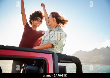 Zwei tausendjährige weibliche Freunde auf einem Road Trip, der in der Rückseite eines oben offenen Auto, Nahaufnahme Stockfoto