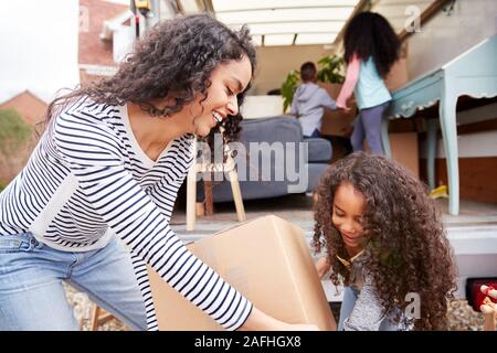 Mutter und Kinder Entladen Möbel aus Ausbau Lkw in neue Home Stockfoto