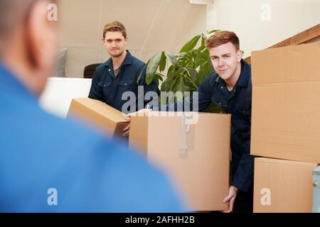 Ausbau Unternehmen Arbeitnehmer Entladen Möbel und Kisten von Lkw in neues Haus am Umzugstag Stockfoto