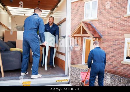 Ausbau Unternehmen Arbeitnehmer Entladen Möbel und Kisten von Lkw in neues Haus am Umzugstag Stockfoto