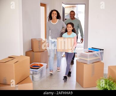 Lächelnd Familie Kisten in die neue Heimat am Umzugstag Stockfoto