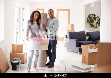 Portrait von lächelnden Paar Kisten in die neue Heimat am Umzugstag Stockfoto