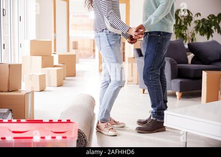 In der Nähe von Paar Hände halten durch Boxen im neuen Haus am Umzugstag Umgeben Stockfoto