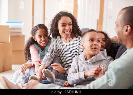 Familie eine Pause und Sitzen auf einem Sofa Feiern in neue Home Gemeinsam Verschieben Stockfoto