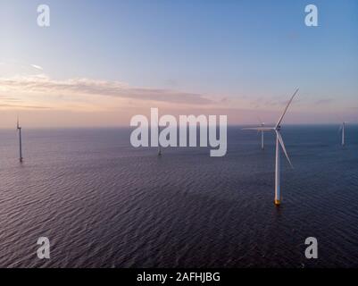 Windmill Park grüne Energie bei Sonnenuntergang im Meer, offshore Wind Mill Turbinen Niederlande Stockfoto