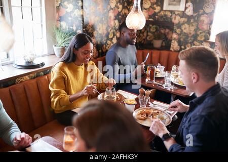 Gruppe von Menschen Essen im Restaurant des geschäftigen traditioneller englischer Pub. Stockfoto