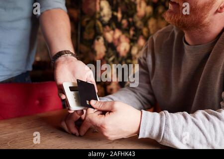 Nahaufnahme des Kunden die Zahlung im Hotel Restaurant mit berührungsloser Kartenleser Stockfoto