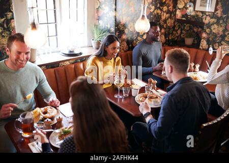 Gruppe von Menschen Essen im Restaurant des geschäftigen traditioneller englischer Pub. Stockfoto