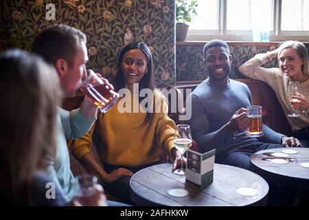 Gruppe von Freunden treffen zum Mittagessen Getränke in traditioneller englischer Pub. Stockfoto