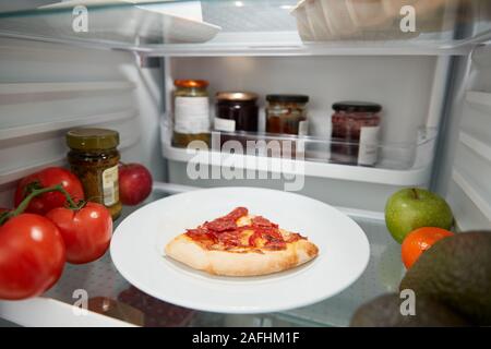 Blick in Kühlschrank Der übrig gebliebene Takeaway Pizza im Regal Stockfoto