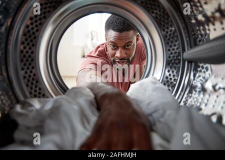 Blick aus dem Inneren Waschmaschine wie Menschen weiße Wäsche suchen Stockfoto