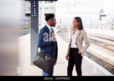 Kaufmann und Kauffrau Pendeln zur Arbeit Gespräch am Bahnsteig warten auf Zug Stockfoto