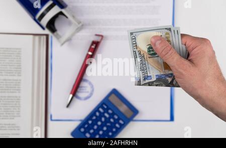 Der Menschen Hand geben US-Dollar auf dem Hintergrund der Dokumente und Stempel. Konzept - Bestechendem und Korruption Stockfoto