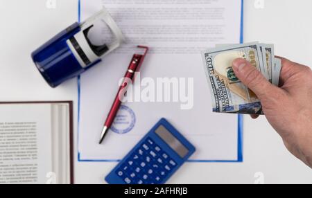Der Menschen Hand geben US-Dollar auf dem Hintergrund der Dokumente und Stempel. Konzept - Bestechendem und Korruption Stockfoto