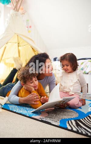 Alleinerziehende Mutter mit Sohn und Tochter in der Höhle im Schlafzimmer zu Hause Stockfoto