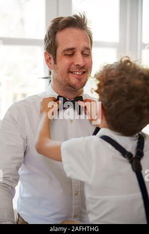 Vater und Sohn tragen Partnerlook immer bereit für die Hochzeit zu Hause Stockfoto