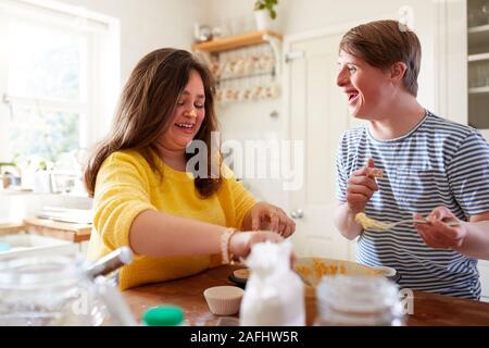 Junge Abstiegsyndrom Paar Spaß Baking Cupcakes in der Küche zu Hause. Stockfoto