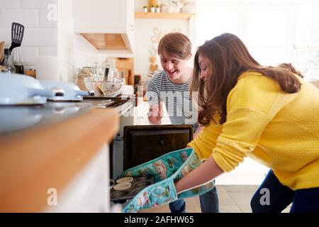 Junge Abstiegsyndrom Paar, hausgemachte Kuchen in den Ofen in der Küche zu Hause. Stockfoto