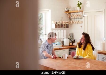 Junge Abstiegsyndrom Paar beim Kaffee und Kuchen in der Küche zu Hause. Stockfoto