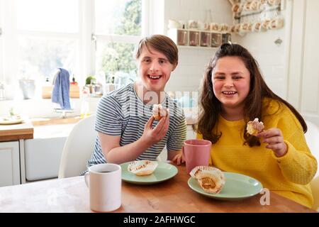 Porträt der jungen Abstiegsyndrom Paar beim Kaffee und Kuchen in der Küche zu Hause. Stockfoto