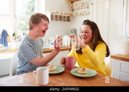 Junge Abstiegsyndrom Paar beim Kaffee und Kuchen in der Küche zu Hause. Stockfoto