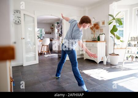 Junge Abstiegsyndrom Mann Spaß tanzen zu Hause Stockfoto