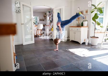 Junge Abstiegsyndrom Mann Spaß Breakdance zu Hause Stockfoto