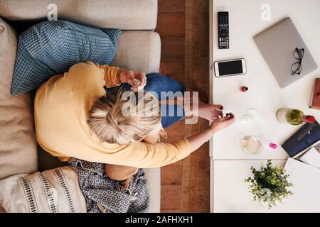 Overhead Shot Suchen auf Frau zu Hause auf dem Sofa liegend Malerei Zehennägel Stockfoto