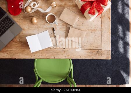 Overhead Shot Suchen auf Leere Weihnachtskarte und wickelte Geschenk Tragen am Tisch Stockfoto
