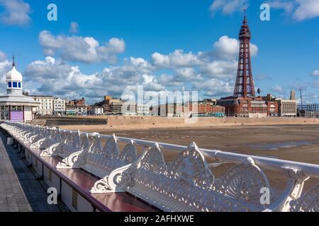 BLACKPOOL, Großbritannien - 12 August: North Pier Bänke mit Blackpool Beach und Turm im Hintergrund an einem sonnigen Tag am 12. August 2019 in Blackp Stockfoto