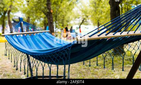 Hängematten hängen zwischen den Bäumen im Wald, auf das grüne Gras und Bäumen. Klaren Tag. Konzept der Sommer rest Stockfoto