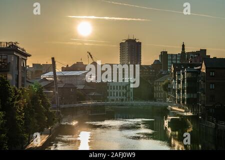 LEEDS, Großbritannien - 13 August: Blick auf den Sonnenuntergang über der Stadt am Fluss Gebäude entlang des Flusses Aire am 13. August 2019 in Leeds Stockfoto