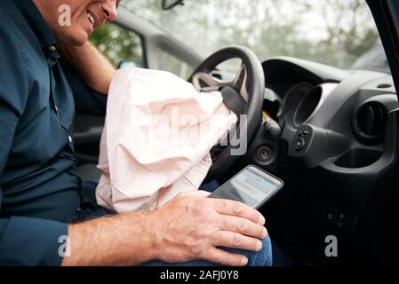 Männliche Autofahrer verletzt im Auto Crash Nach über Handy während der Fahrt Stockfoto