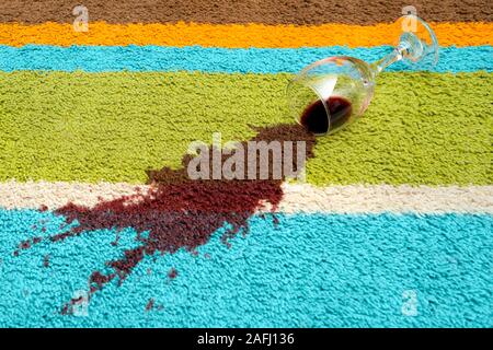 Auslaufen von Rotwein auf dem Teppich Stockfoto
