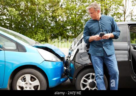 Reife männliche Autofahrer bei Autounfall, Versicherung oder Recovery Service beteiligt Stockfoto