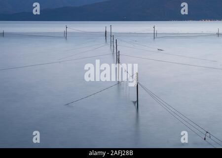 Fischernetze im Meer vor dem dunklen, langen Belichtung Stockfoto