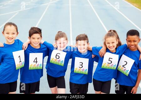 Portrait von Kindern auf der Leichtathletikbahn tragen Wettbewerber Zahlen auf Sport Tag Stockfoto