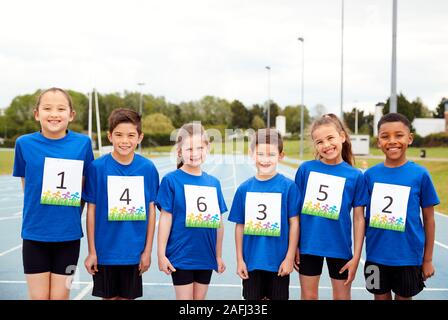 Portrait von Kindern auf der Leichtathletikbahn tragen Wettbewerber Zahlen auf Sport Tag Stockfoto