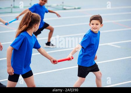 Kinder in der Athletik Team im Staffellauf konkurrierenden auf Sport Tag Stockfoto